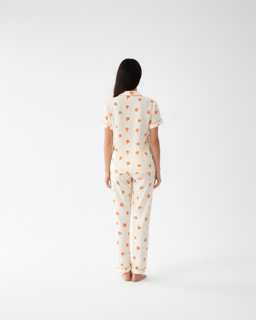 Crèmekleurige damespyjamaset met oranje print – top met korte mouwen en knoopsluiting en broek