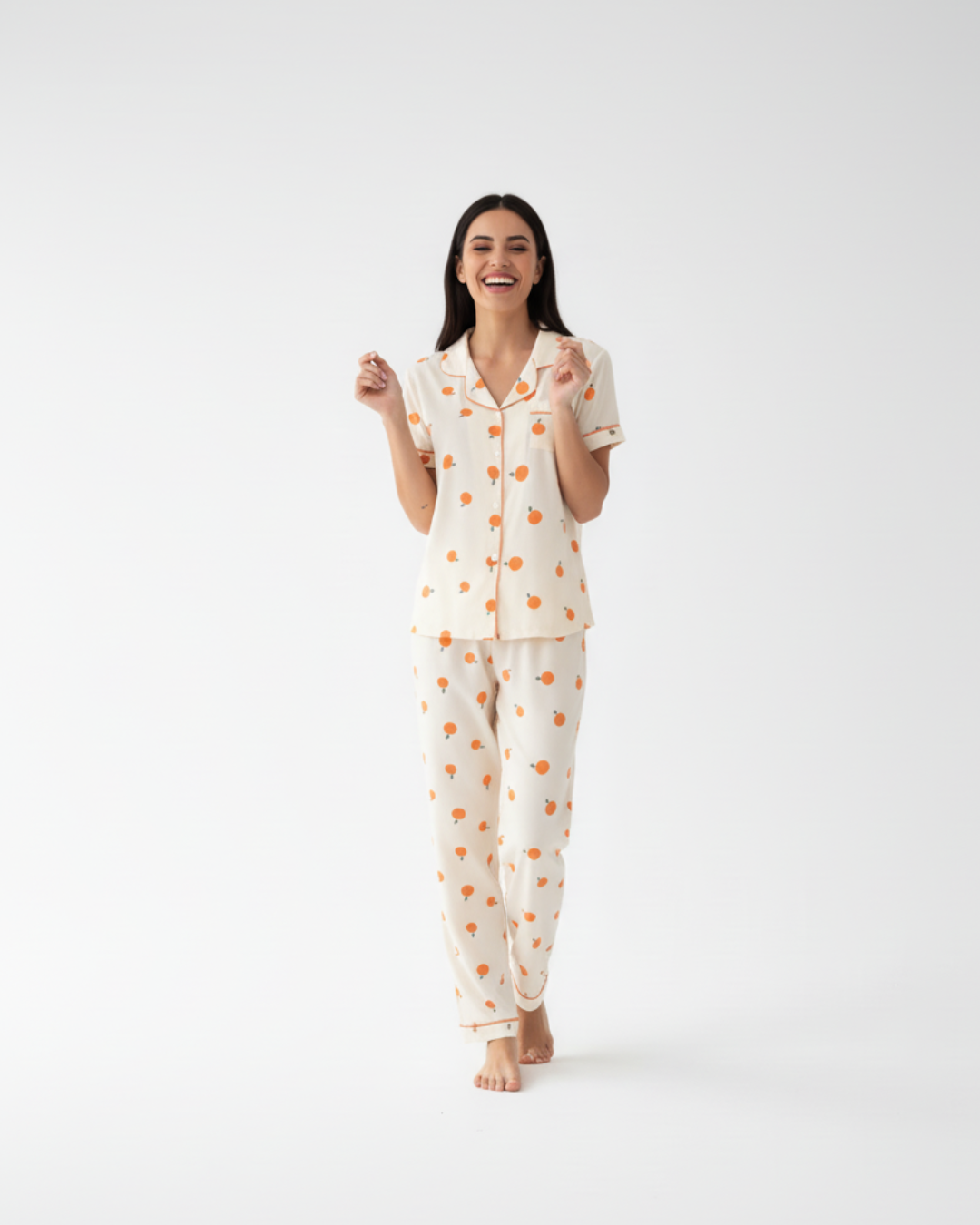 Crèmekleurige damespyjamaset met oranje print – top met korte mouwen en knoopsluiting en broek